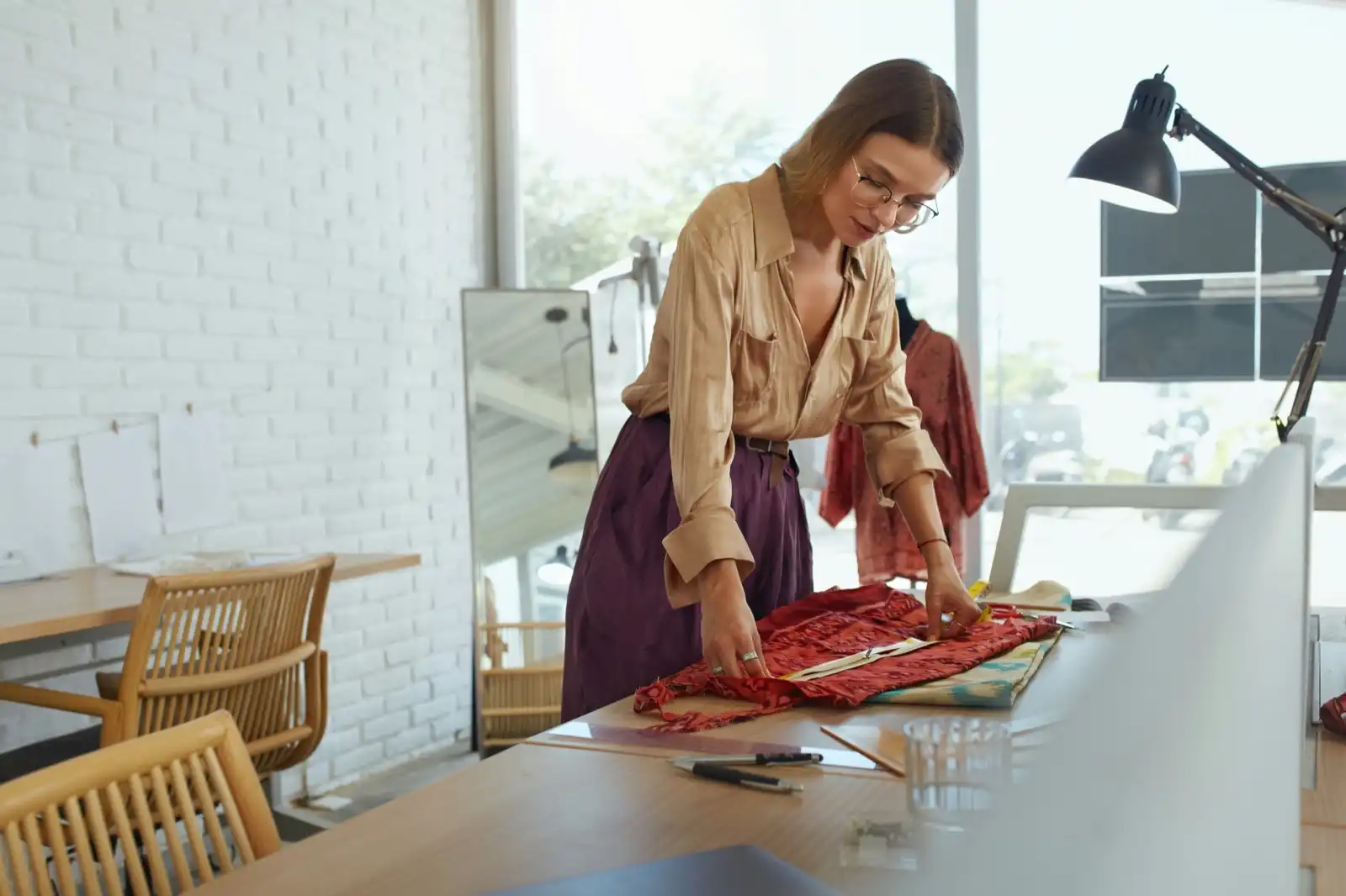 A designer measuring fabric on a studio table