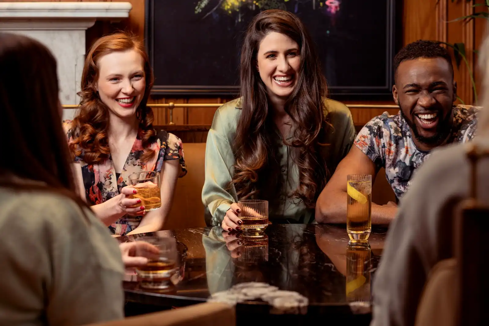 Friends around a table sharing whisky